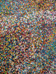 Multicolored abstract background on a stone surface. Spray dots. Red, blue, yellow. Vertical image.