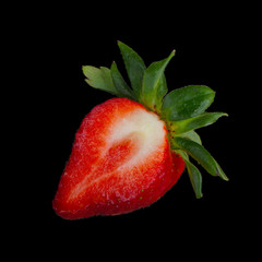 half of strawberry isolated on black background