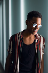 young handsome attractive guy in sunglasses posing in the neon light of the night city