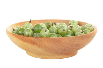 heap of gooseberries in wooden plate isolated on white background