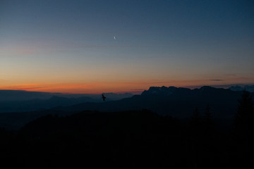 Vogel bei Sonnenaufgang mit Mond und Bergpanorma