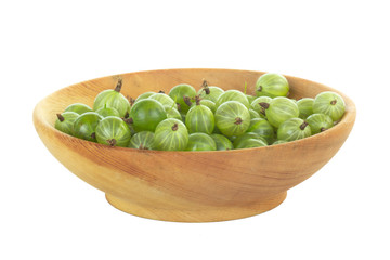 heap of gooseberries in wooden plate isolated on white background