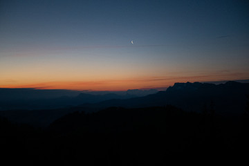 Mond bei Sonnenaufgang mit Bergpanorama