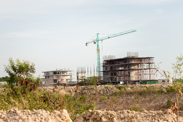 Fototapeta na wymiar Construction site including several cranes working on a building complex. Construction Site, construction machinery,factory