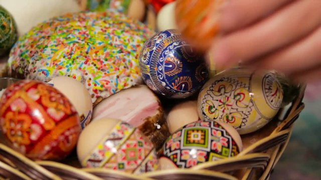 puts Easter eggs in Easter basket,a woman puts Easter eggs in a basket, Ukrainian traditions in paska