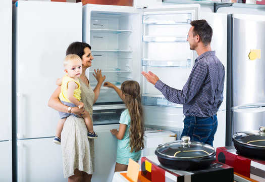 family of four shopping new refrigerator in home appliance store