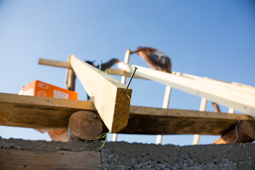 Roofer, carpenter on the roof, he closes the roof of a small and cozy house
