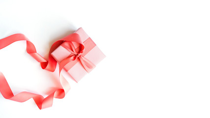 Coral gift box with a coral ribbon on a white background .