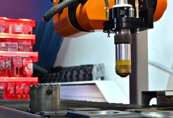 CNC Laser Plasma cutting head, close-up. Modern technology in process at metalworking manufacturing plant.  Shooting in real conditions, a slight blur of focus