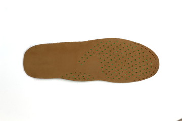 Perforated insole in shoes of genuine leather of brown color on a white background.