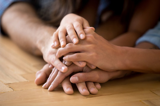 Close up of loving family stack hands showing unity