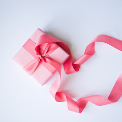 Pink gift box with a pink ribbon on a white background .