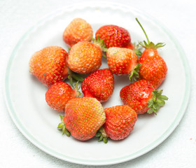 Strawberries on a white background, fresh, tasty and natural strawberries from grandfather's garden on a white plate