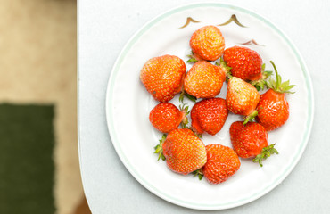 Strawberries on a white background, fresh, tasty and natural strawberries from grandfather's garden on a white plate
