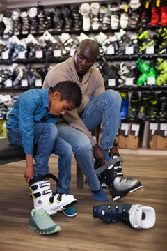 Man With Son Trying On Ski Boots