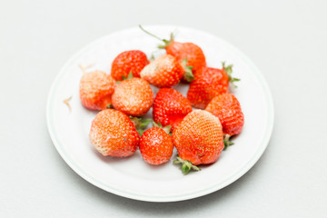 Strawberries on a white background, fresh, tasty and natural strawberries from grandfather's garden on a white plate