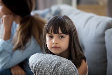 Upset little girl hug pillow lack mom attention