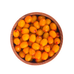 heap of sea buckthorn in wooden cup isolated. top view