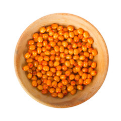 heap of sea buckthorn in wooden plate isolated. top view