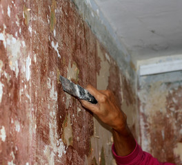Preparing walls for wallpaper with a spatula. Repair in the apartment.