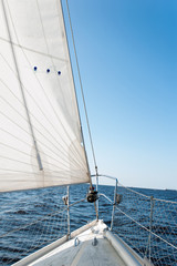 Obraz premium White sailing yacht at a speed swims to shore