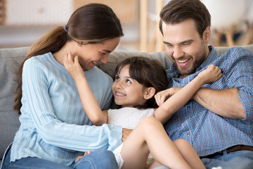 Cute little girl have fun relaxing at home with parents