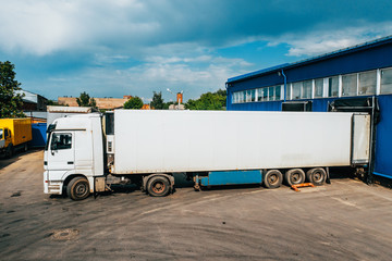 Cargo truck in industrial warehouse or logistic center waiting for loading goods