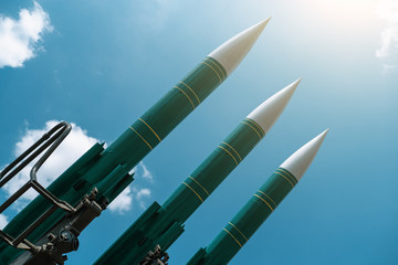 Ballistic missiles on blue sunny sky background, anti aircraft forces, military industry. War and peace concept