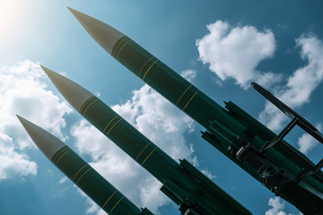 Ballistic missiles on blue sunny sky background, anti aircraft forces, military industry. War and...