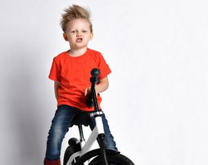 Young boy kid in orange t-shirt biker ride bicycle happy screaming 