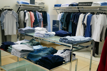 Men's clothing store. Shelves with men's fashion clothes.