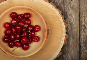 cherry in wooden plate on wooden background