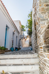 Fototapeta na wymiar Traditional alley in Batsi village of Andros, on a sunny day, Cyclades, Greece