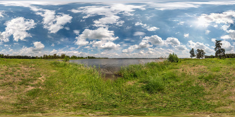 full seamless spherical hdri panorama 360 degrees angle view on grass coast of huge lake or river in sunny summer day and windy weather with beautiful clouds in equirectangular projection, VR content