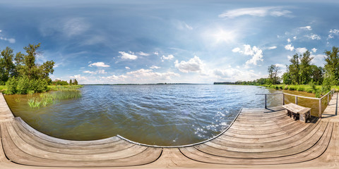 full seamless spherical hdri panorama 360 degrees  angle view on wooden pier of huge lake or river...