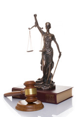 statue of justice, judge's hammer behind books on a white background