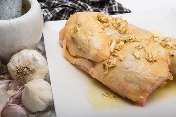 A piece of chicken in a plate with garlic