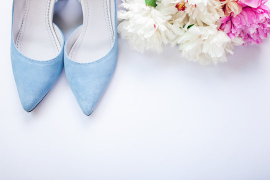 Female blue wedding shoes with flowers on white background