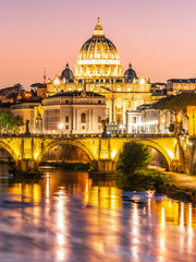 St Peters Basilica in Vatican and Ponte Sant'Angelo Bridge over Tiber River at dusk. Romantic evening cityscape of Rome, Italy