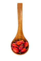 heap pf red hips in wooden spoon isolated on white background. top view