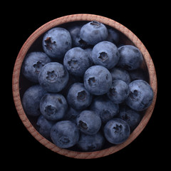 heap of blueberry in wooden cup isolated on black background. top view