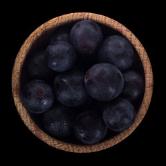 heap of black grapes isolated on black. top view