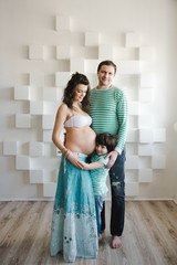 Portrait of happy little boy hugging mother's pregnant belly . New life concept. Happy second...