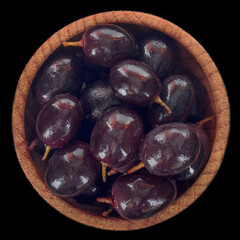 heap of black grapes isolated on black. top view