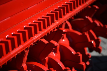 A red industrial roller of an agriculture machine.