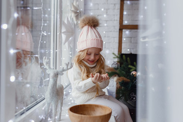 Little girl sitting on a window sill