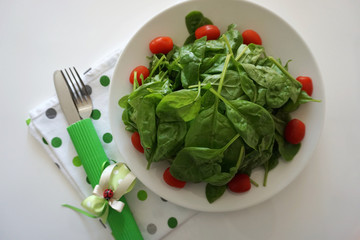 Fresh organic green spinach leaves served on the plate. Healthy food and eating concept