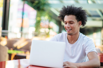 Victorious handsome man looking at his laptop while sitting in bright living room