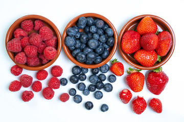 Frische Beeren in Schalen auf weißem Hintergrund