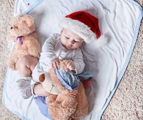 happy baby in Santa's hat with soft toys